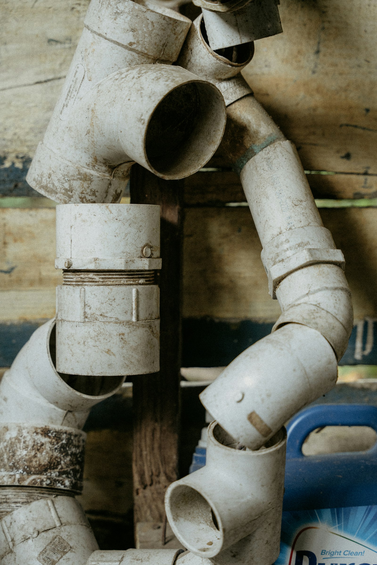 Close-up of a plumber's hand holding a pipe wrench next to copper central heating pipes and neatly laid out tools