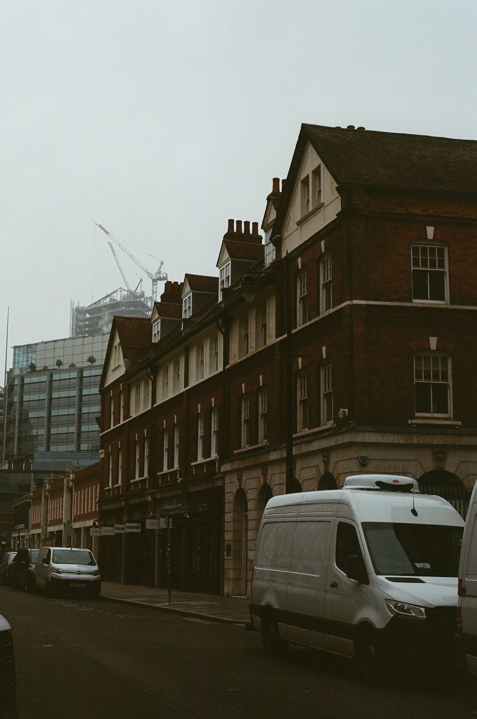 Roofer's van parked on an Essex residential street with ladders on the roof rack and rolls of felt visible in the back
