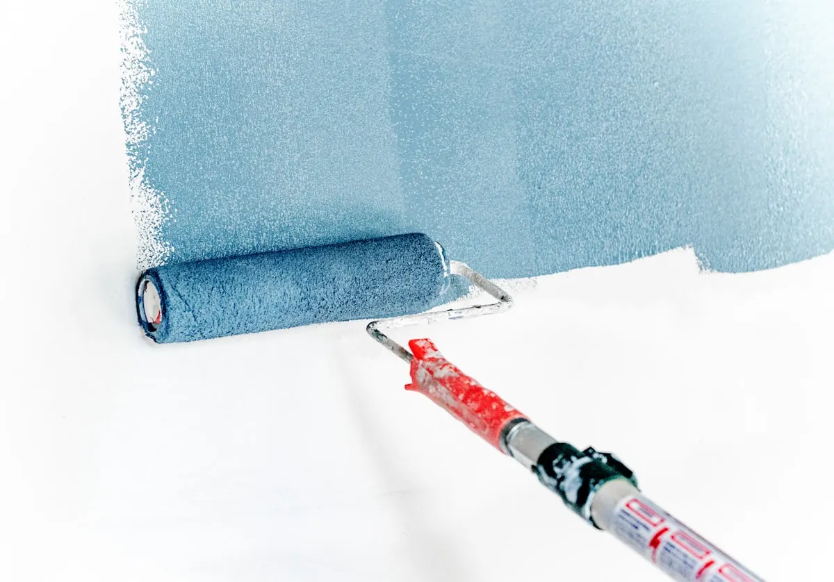 Painter and decorator rolling paint onto an interior wall