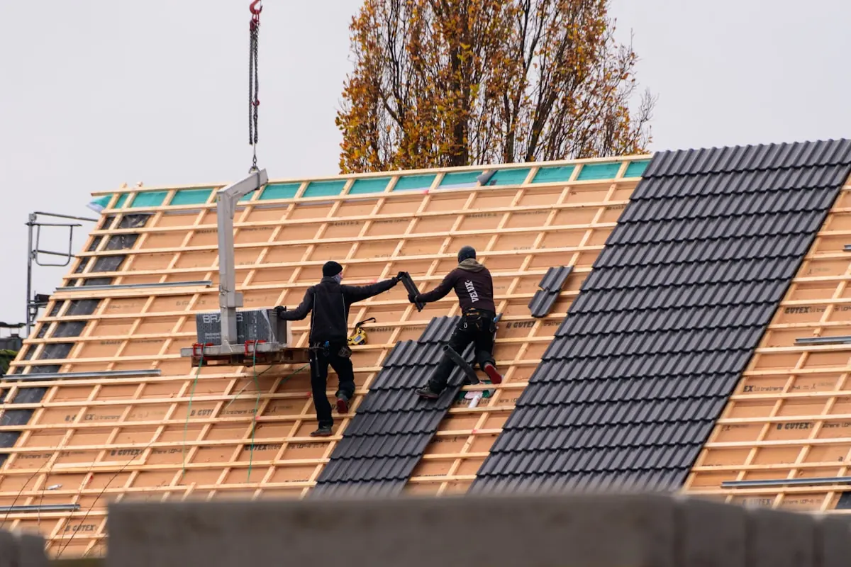 Roofer installing slate tiles on a pitched roof in Essex